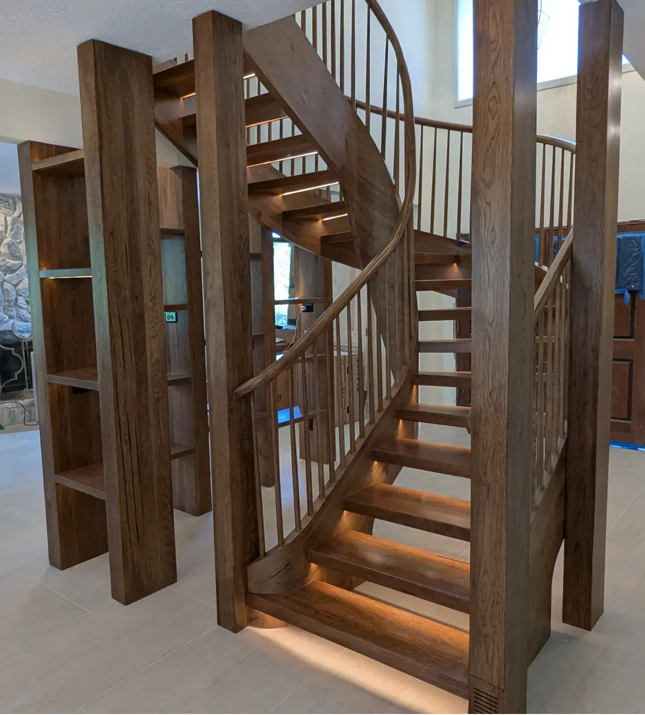 Custom U-shaped floating hickory staircase with L-shaped shelving and integrated mortised LED strip lighting